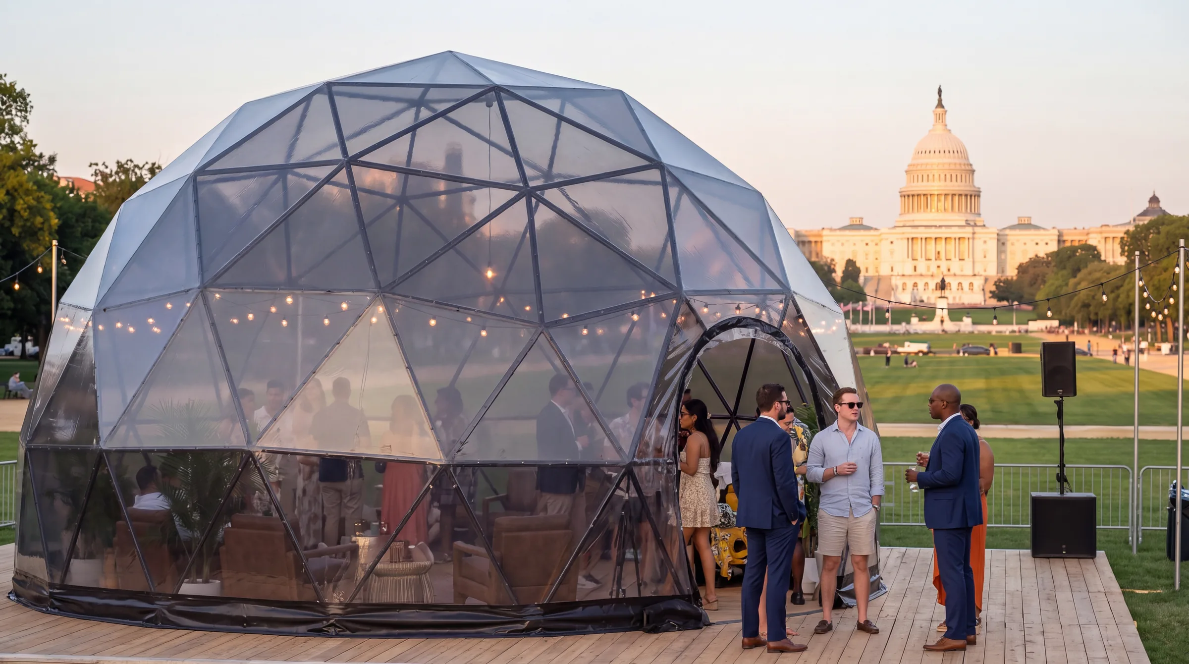 Clear geodesic event dome hosting a reception on a lawn