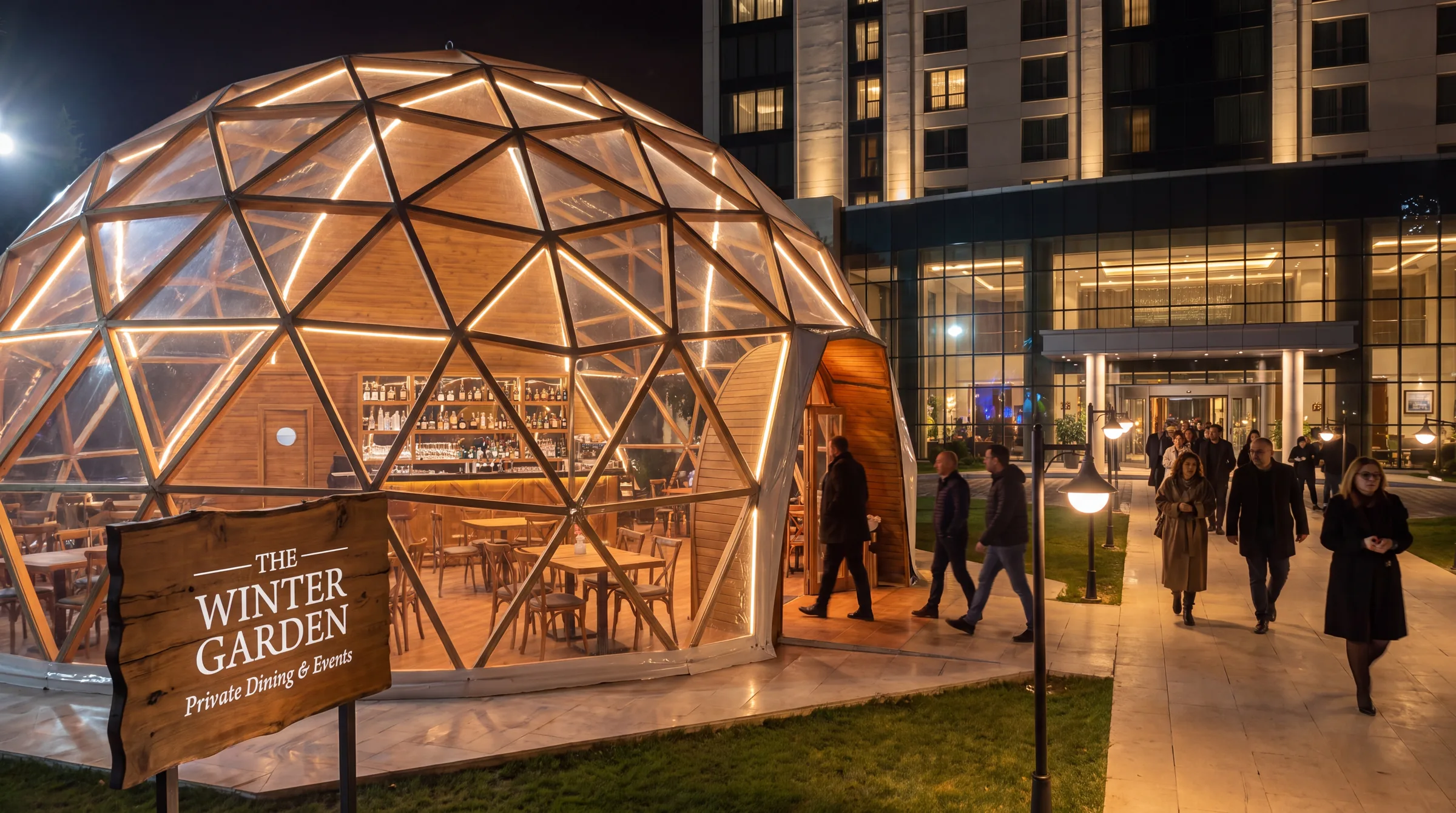 The Winter Garden event dome lit at night beside a hotel entrance