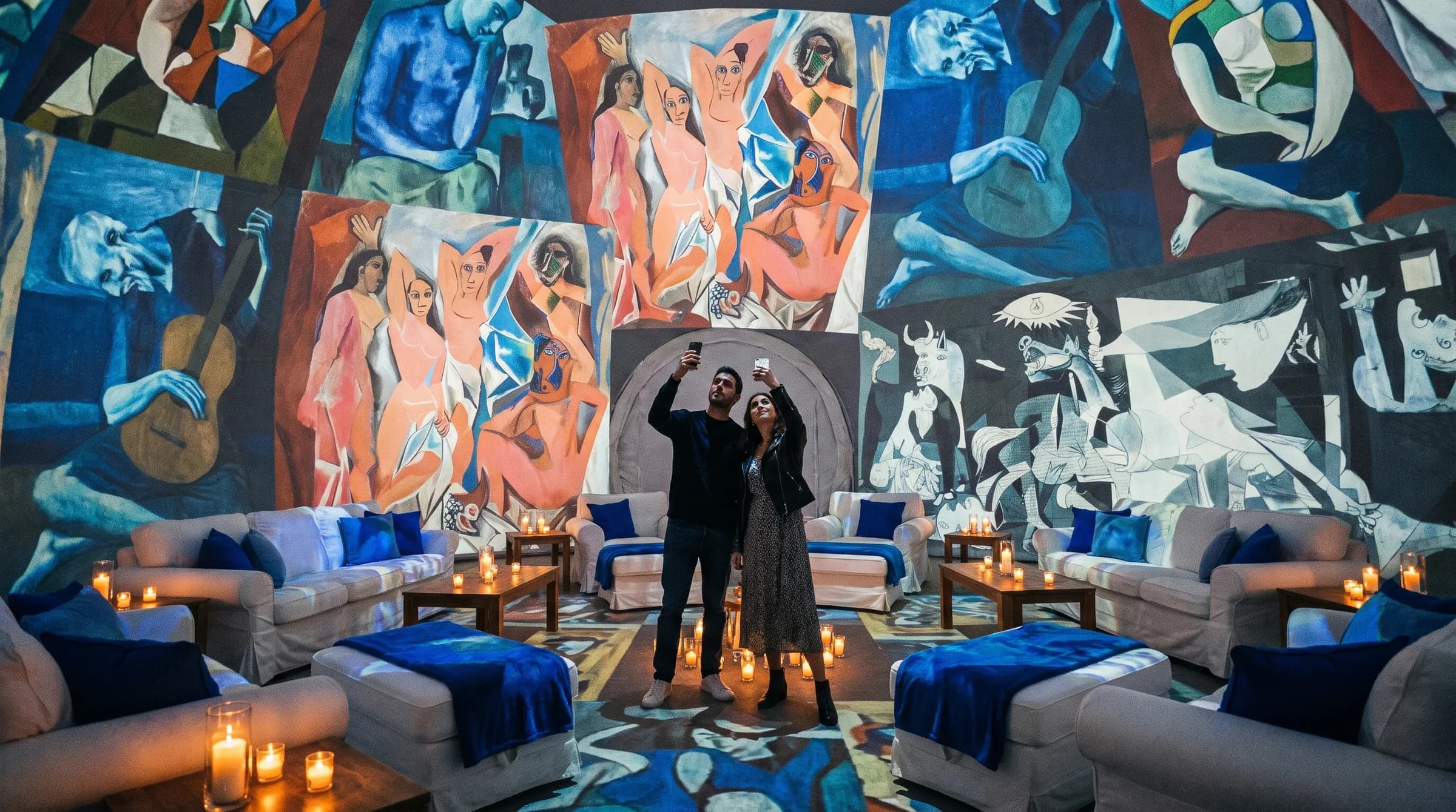 Guests inside a projection dome with artwork projected across the walls and a lounge seating area