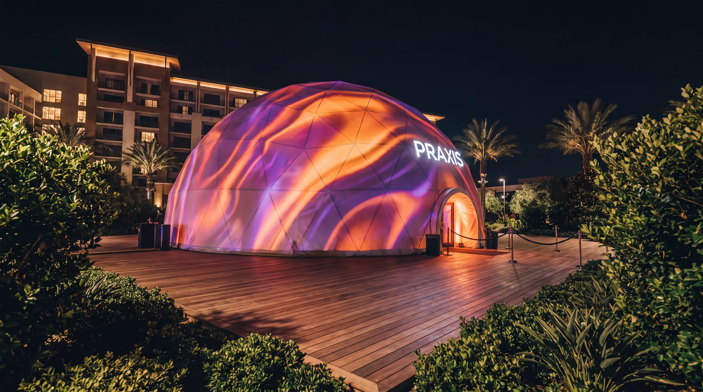 Projection dome illuminated at night with visuals across its exterior
